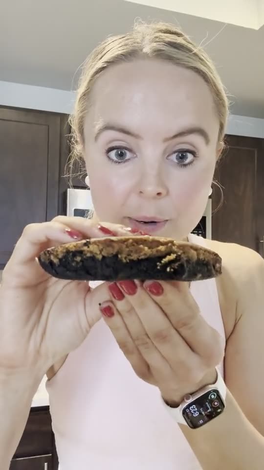 Addison LaBonte taste-testing a brookie in her kitchen